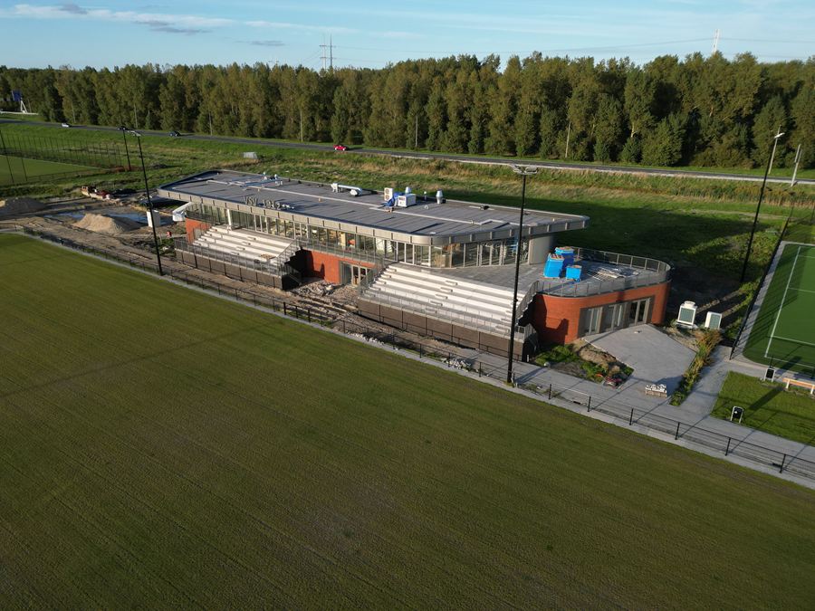 Dronefoto van het clubhuis met tribune langs het hoofdveld