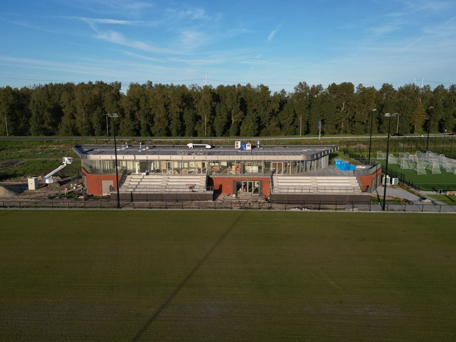 Het clubhuis met tribune, laag boven het veld gefotografeerd