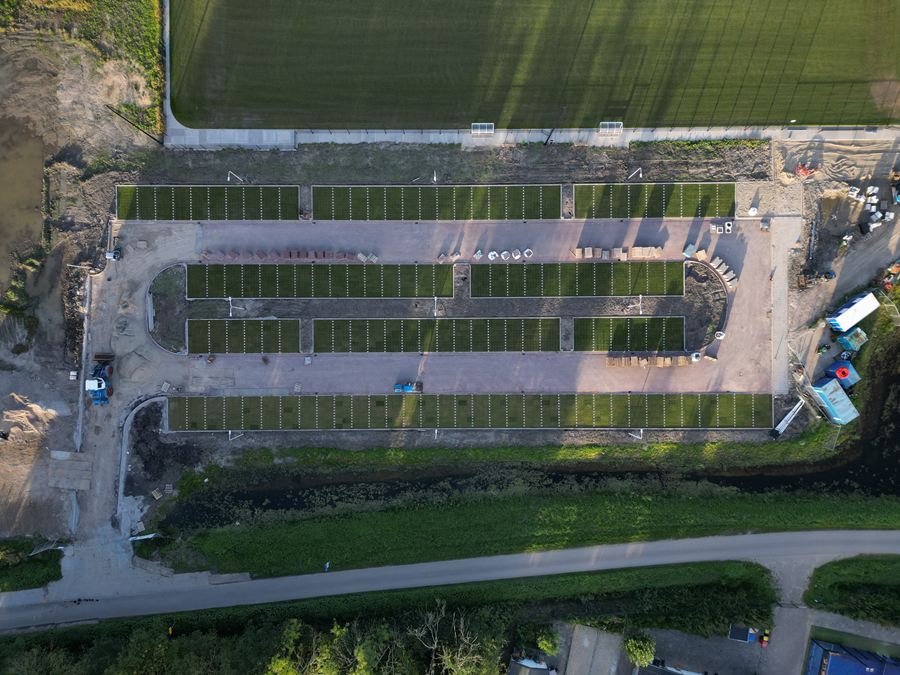 Recht van boven: een parkeerterrein in aanleg naast een veld