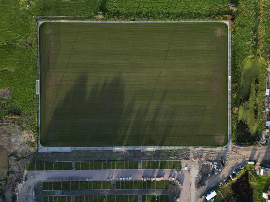 Recht van boven: een volledig veld met het parkeerterrein ernaast