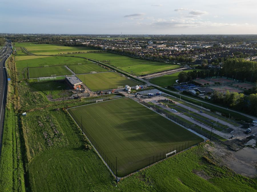 Overzicht van het sportpark met de woonwijk erachter
