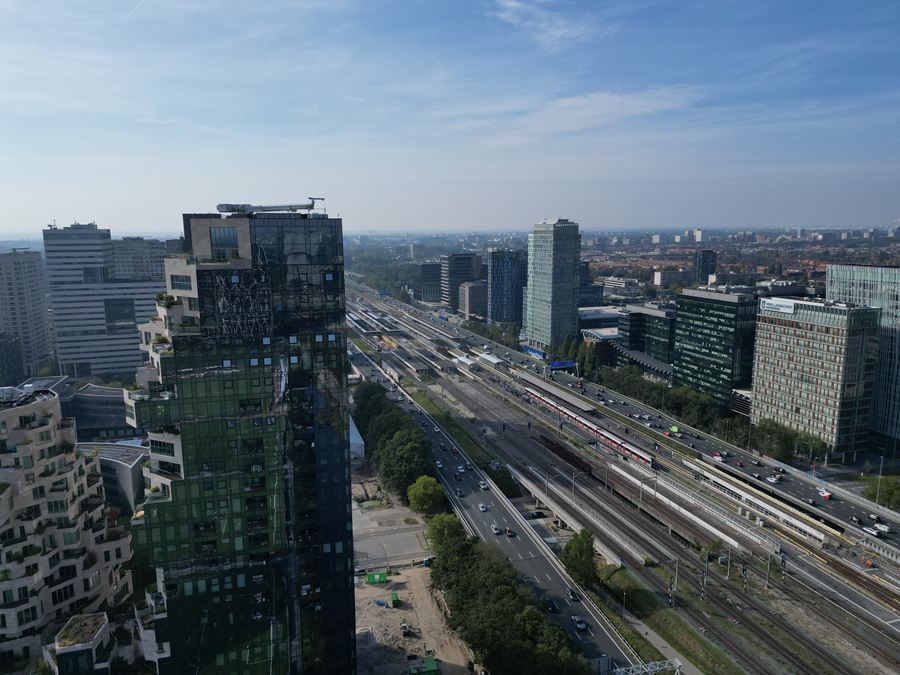 Kantoortorens van de Zuidas langs het spoor en de snelweg