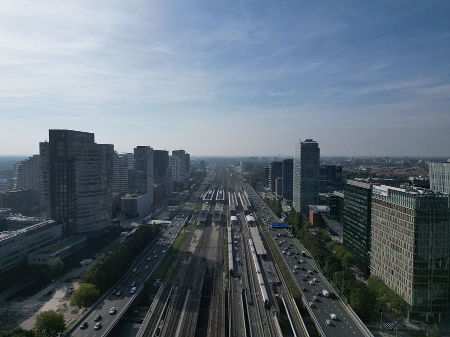 Recht boven het spoor, met de torens van de Zuidas aan beide kanten