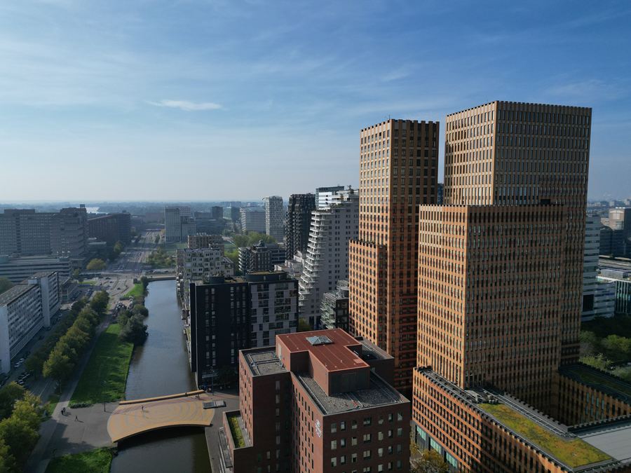Bakstenen torens aan de gracht, met de stad erachter