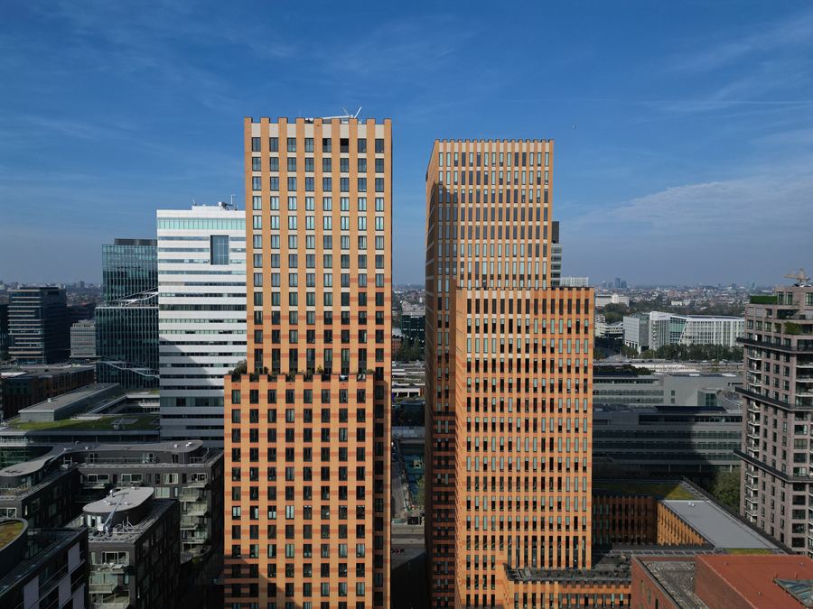 Twee bakstenen torens van dichtbij tegen een blauwe lucht